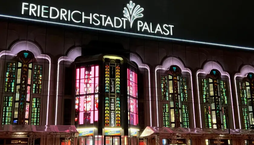 Friedrichstadt-Palast, ein Wahrzeichen Berlins, erstrahlt in bunten Lichtern. Ein Muss für alle, die historische Orte in Berlin erleben wollen.