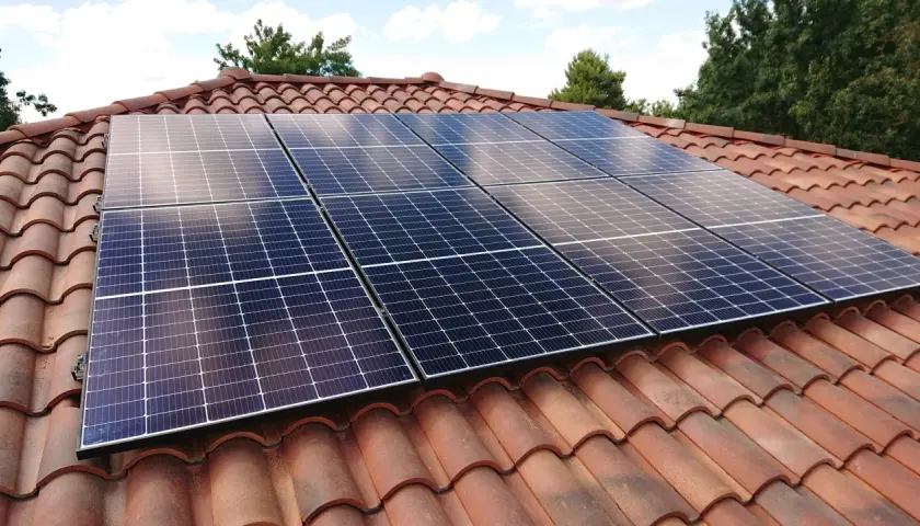 Panneaux solaires sur un toit de tuiles, assurant une production d'énergie durable. La durée de vie panneau solaire est longue.