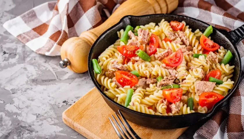 Makaron fusilli z tuńczykiem, pomidorkami i fasolką szparagową w patelni.