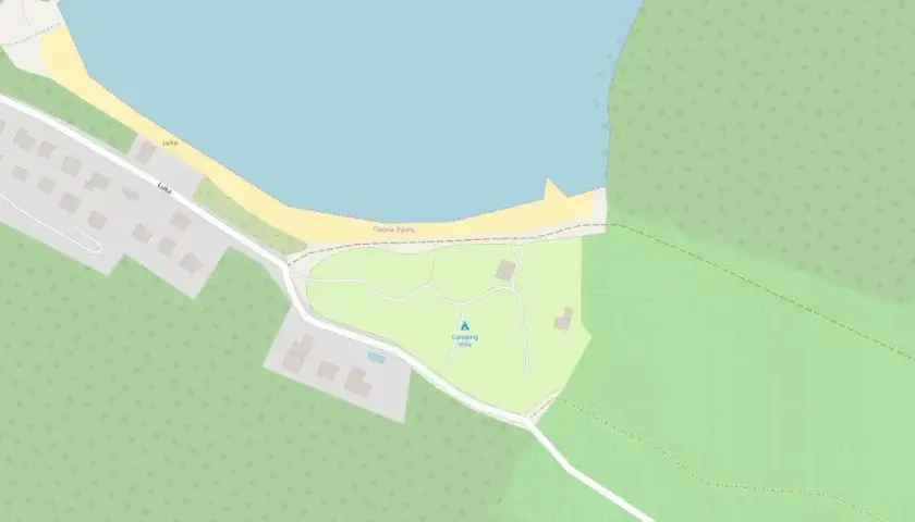 Mapa pokazuje obszar z zabudowaniami, drogami i linią brzegową. Widać tu camping Vrila, otoczony zielenią i blisko morza.
