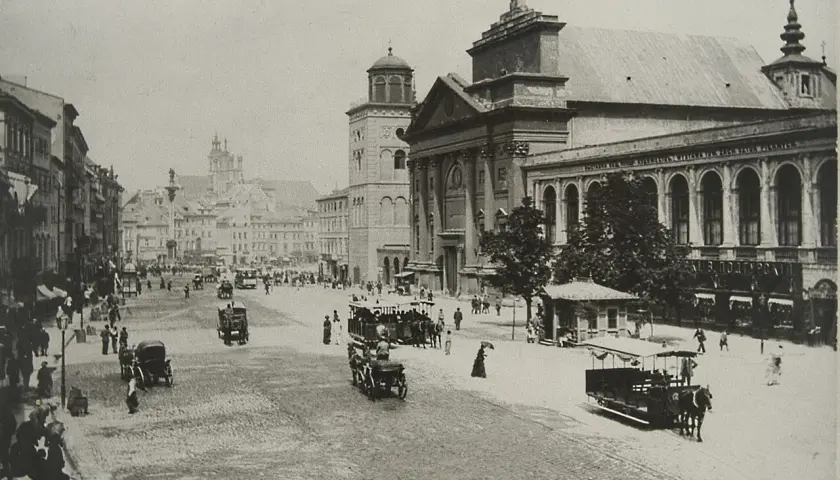 Dawny plac miejski z tramwajami konnymi i ludźmi. Motyw miasta w lalce, jakby zatrzymany w czasie.