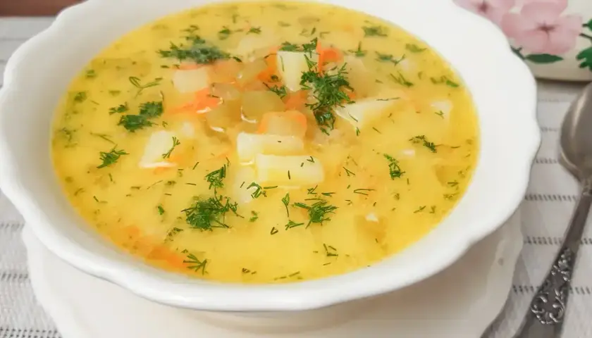 Aromaticzna zupa ogórkowa z ziemniakami i marchewką, posypana świeżym koperkiem. Idealna na chłodne dni.