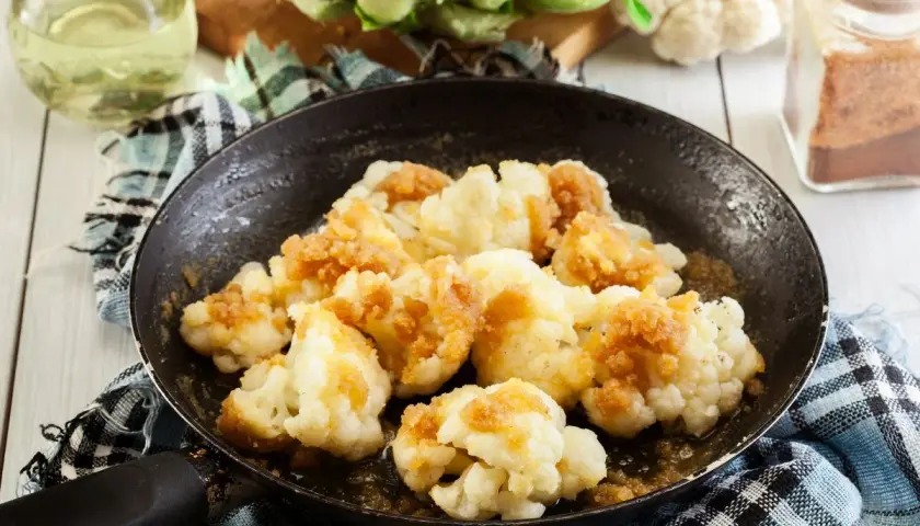 Cavolfiore gratinato in padella, dorato e croccante, pronto per essere gustato. Un contorno semplice e saporito.