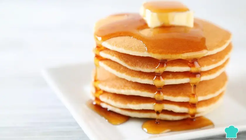 Pila de panqueques esponjosos con mantequilla y miel, perfecta para tu próxima receta.