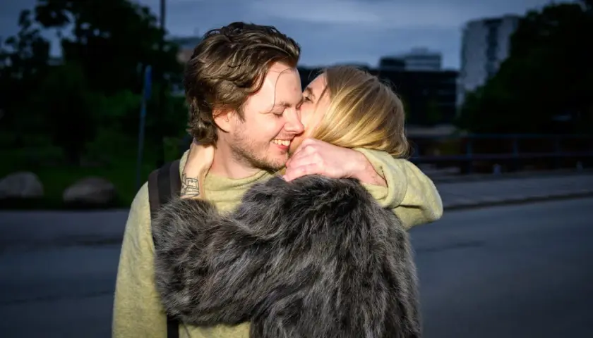 Amanda Romare och hennes lilleman omfamnar varandra lyckligt i skymningen.