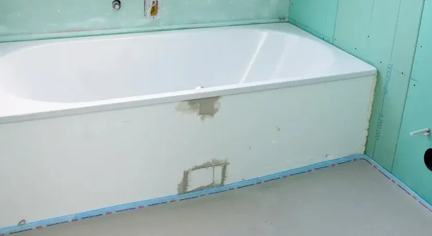 Badewanne in einem Rohbau. Die Anschlussfugen abdichten ist der nächste Schritt, bevor die Fliesen verlegt werden.