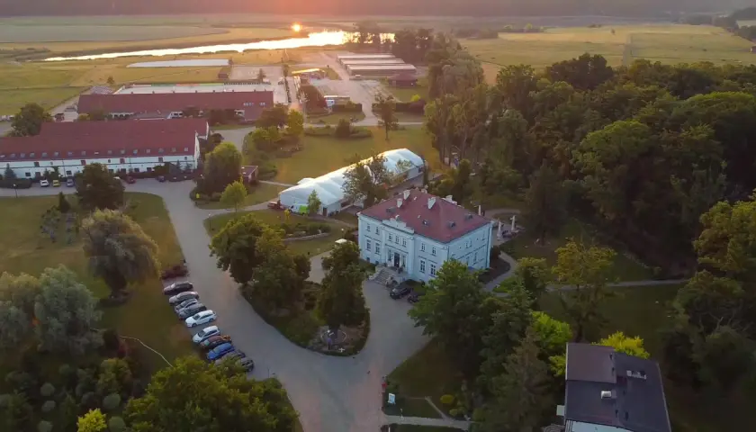 Widok z lotu ptaka na hotel Jakubus z otaczającym go parkiem i stawem w tle.