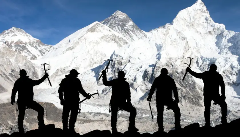 Pięciu alpinistów z czekanami na tle ośnieżonego Mount Everestu. To symboliczne przedstawienie, bo ile osób weszło na Mount Everest, to już inna historia.