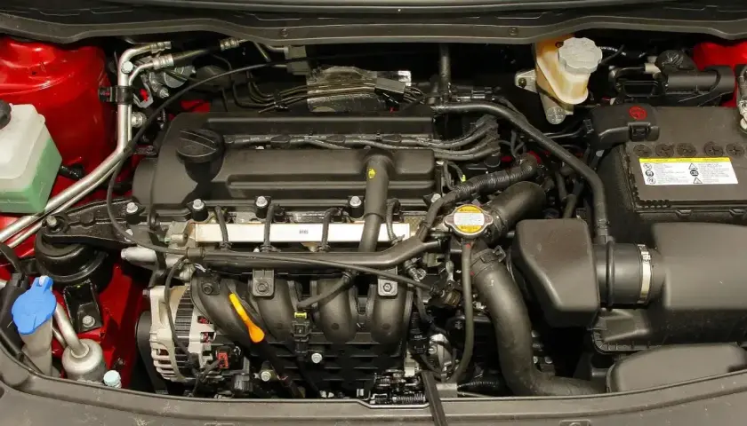 Silnik Hyundai i20 2010. Widoczny alternator, akumulator, płyny i przewody.
