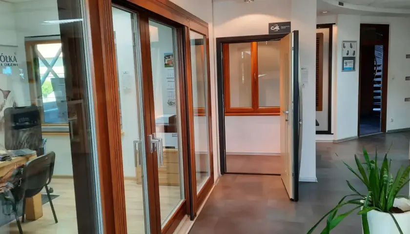 Salon okien i drzwi z drewnianymi ramami, przeszklonymi drzwiami i otwartymi drzwiami.
