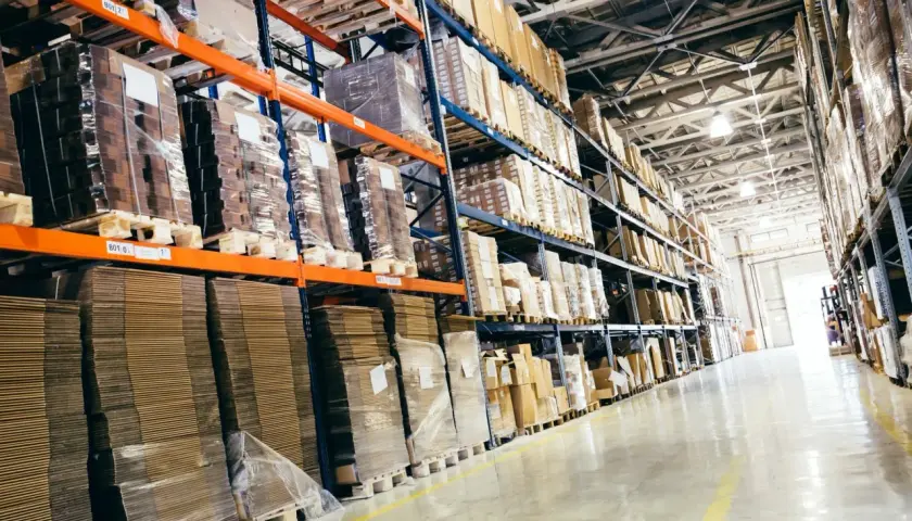 Wielkie regały magazynowe pełne paczek i palet, idealne do studiów logistycznych.