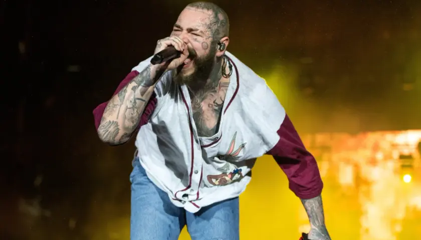 Post Malone Polska na koncercie, śpiewa z pasją w koszulce z Królikiem Bugsem i dżinsowych szortach.