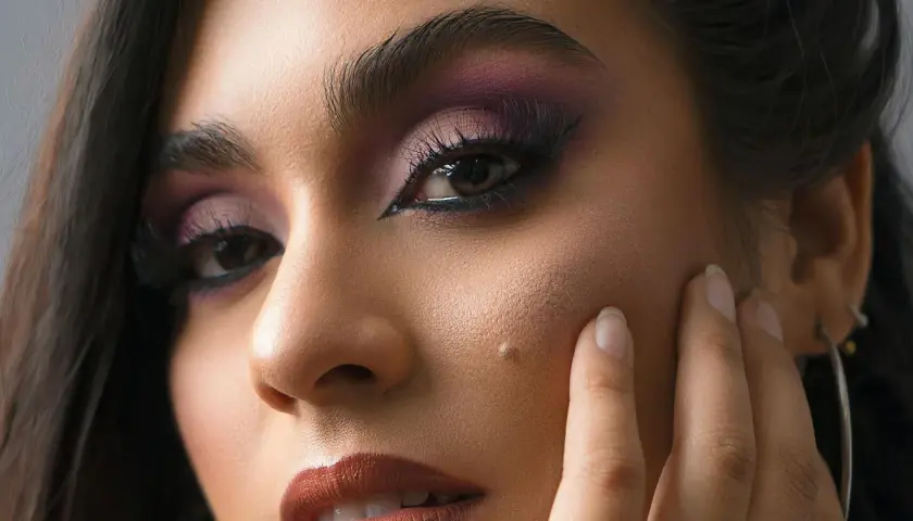 Un regard intense avec un maquillage des yeux en noir, rehaussé de fard à paupières violet.