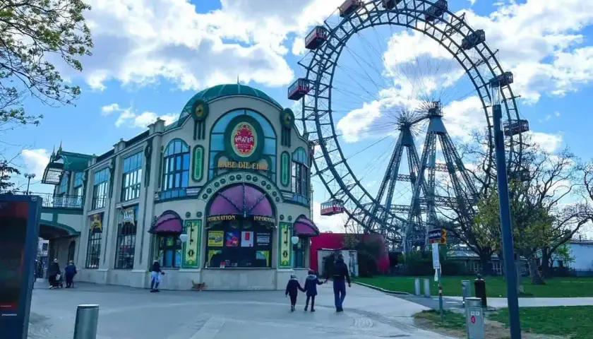Una famiglia passeggia verso la ruota panoramica del Prater, un'attrazione iconica per una gita a Vienna con i bambini.