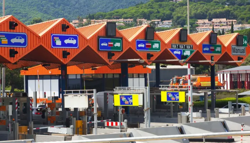 Carriles de peaje con señales que indican cómo pagar. Hay señales para coches y camiones, y una para pago manual.