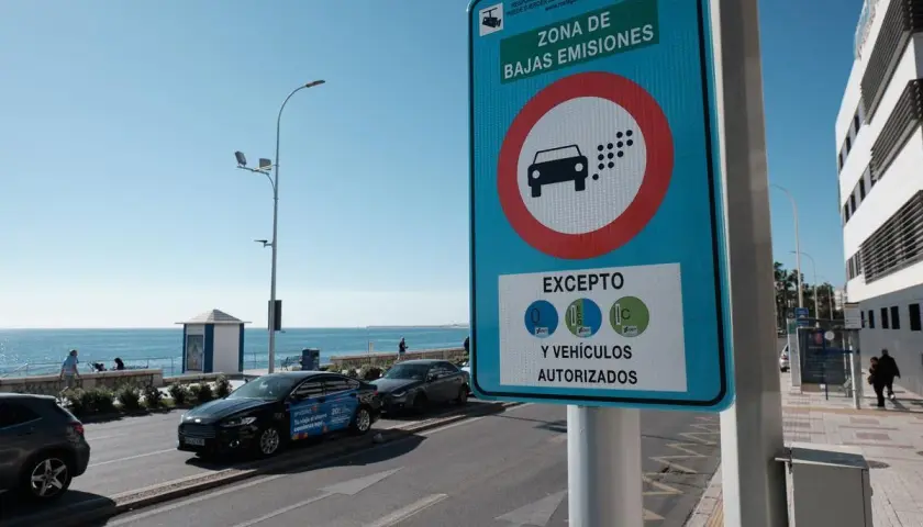 Señal de "Zona de Bajas Emisiones" (ZBE) con un coche y puntos de emisión. Indica excepciones para vehículos con distintivos C, ECO y 0.