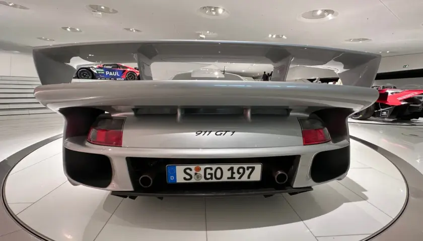 Srebrne Porsche 911 GT1 z masywnym spojlerem, gotowe do wyścigu.