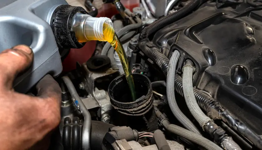 Vertiendo aceite de motor, una tarea común al considerar la diferencia entre aceite 5w40 y 10w40.