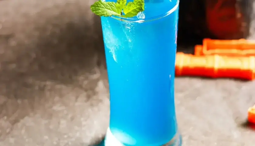 Błękitny drink z Blue Curaçao, lodem i miętą w szklance.