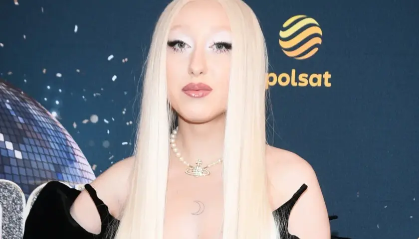 Luna w stylizacji na Eurowizję, z długimi blond włosami i perłowym naszyjnikiem.