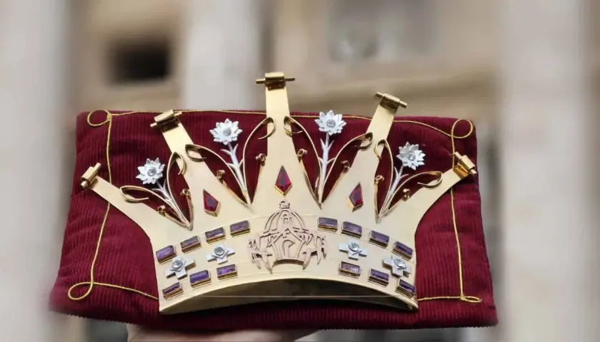 Goldene Tiara Papst, verziert mit Edelsteinen und Blumen, ruht auf einem roten Samtkissen.