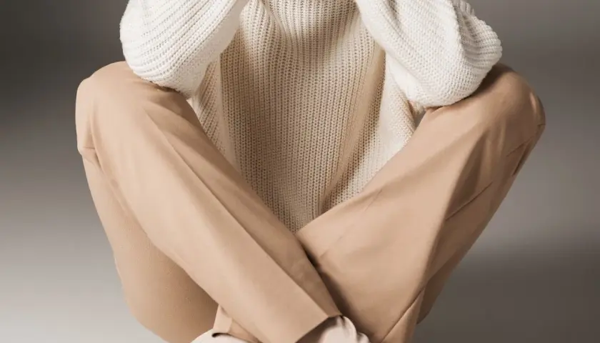 Eleganckie beżowe spodnie i biały sweter tworzą stylową, minimalistyczną stylizację.