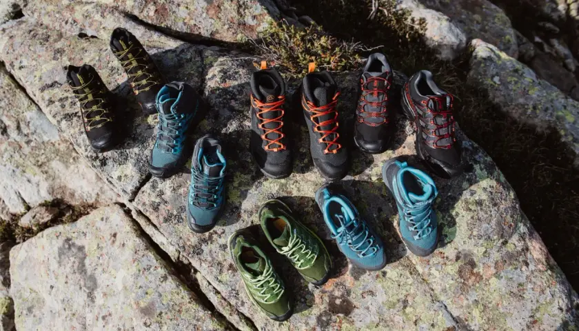 A collection of hiking boots and shoes in various colors, arranged on rocks. Even well-made shoes can degrade over time if not worn, a process that can seem mysterious.