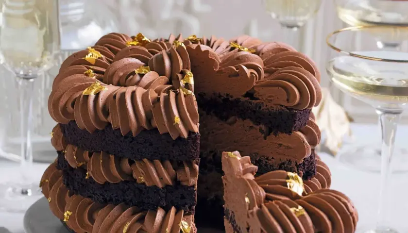 Torta a strati con pan di spagna al cacao, ricoperta da una golosa crema al cioccolato e decorata con foglia d'oro.