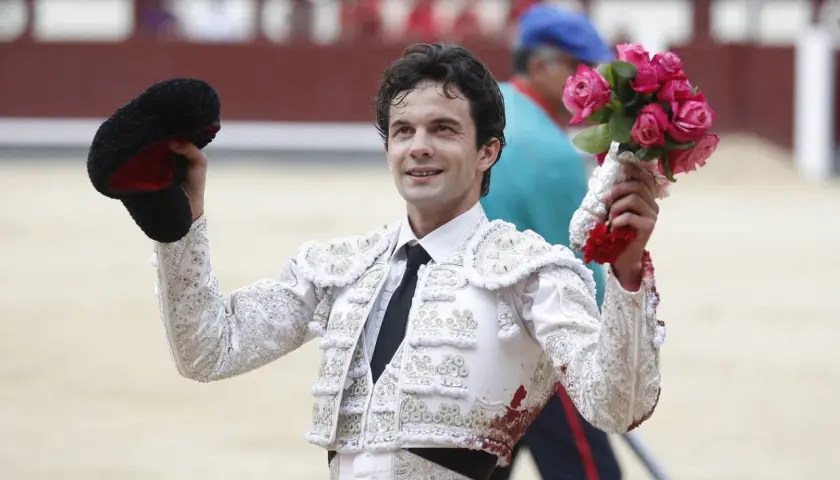 Juan del Álamo, torero, sonríe con un ramo de rosas en la mano y su montera en la otra, tras una faena.
