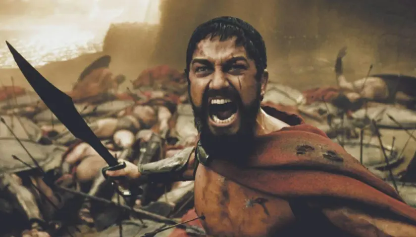 Leonidas, med svärdet höjt, vrålar i strid bland fallna krigare. En ikonisk scen från rollistan i 300.