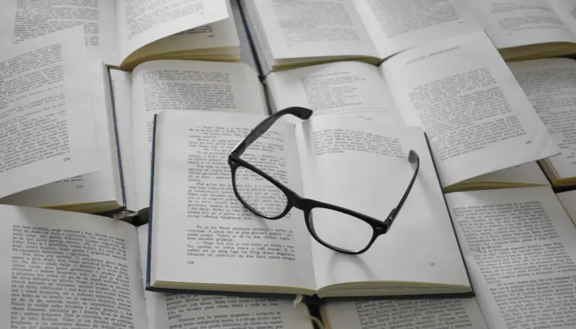Lunettes posées sur des livres ouverts. Ces figures de style servent à enrichir le texte et à rendre la lecture plus captivante.