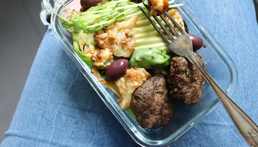En snabb matlåda med köttbullar, blomkål, avokado och oliver. Perfekt för en hälsosam lunch på språng.