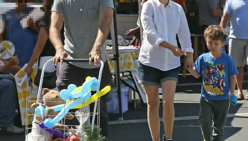 Natalie Portman z dziećmi na targu. Syn trzyma ją za rękę, a w wózku widać pluszowego misia i balony.