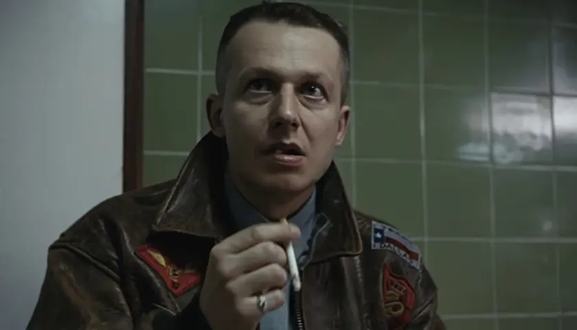 Władysław Pasikowski, reżyser filmu Kroll, w skórzanej kurtce, z papierosem w dłoni.