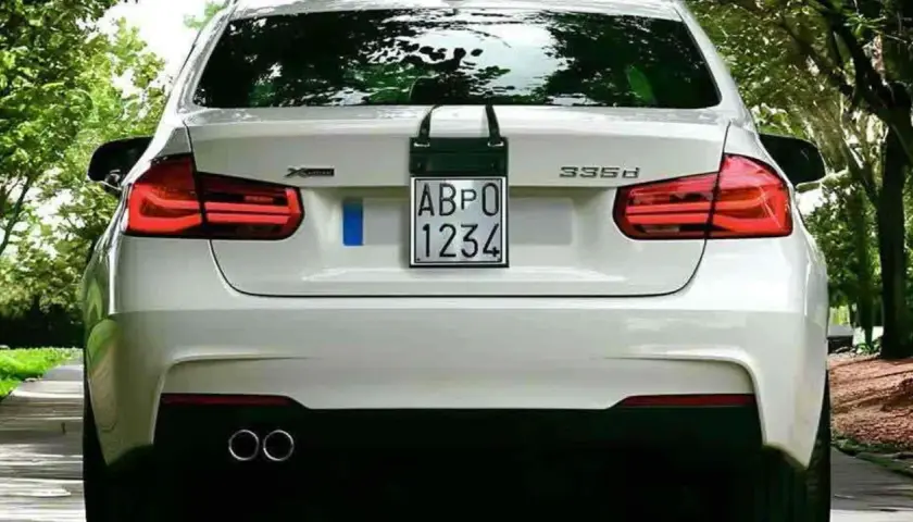 Parte posteriore di un'auto bianca con targa prova "ABPO 1234" appesa.