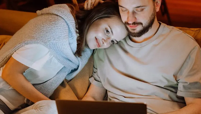 Para spędza czas razem, kobieta opiera głowę na ramieniu mężczyzny. Ich bliskość emanuje spokojem, jak w praktykach tantra.