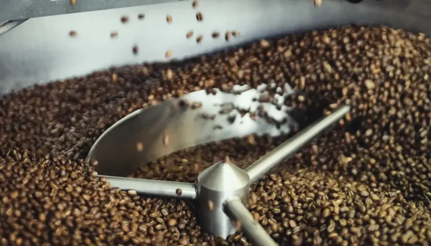 Proces palenia kawy w maszynie. Ziarna kawy wirują, nabierając idealnego koloru i aromatu.