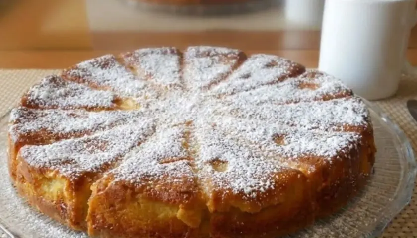 Gâteau mascarpone saupoudré de sucre glace, prêt à être dégusté avec une tasse de café.