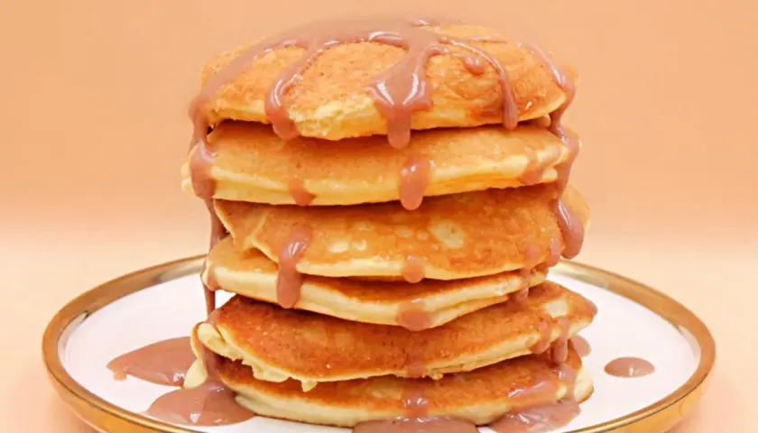 Stos puszystych naleśników polanych sosem. Czy pancake są zdrowe? Zależy od składników i dodatków!