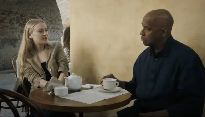 Denzel Washington i Dakota Fanning rozmawiają przy stoliku w kawiarni. To scena z filmu "Bez litości obsada".