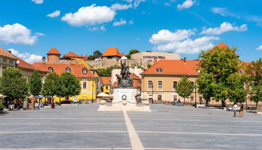 Rynek w Egerze z pomnikiem i zamkiem w tle. Odkryj atrakcje Egeru i okolic!