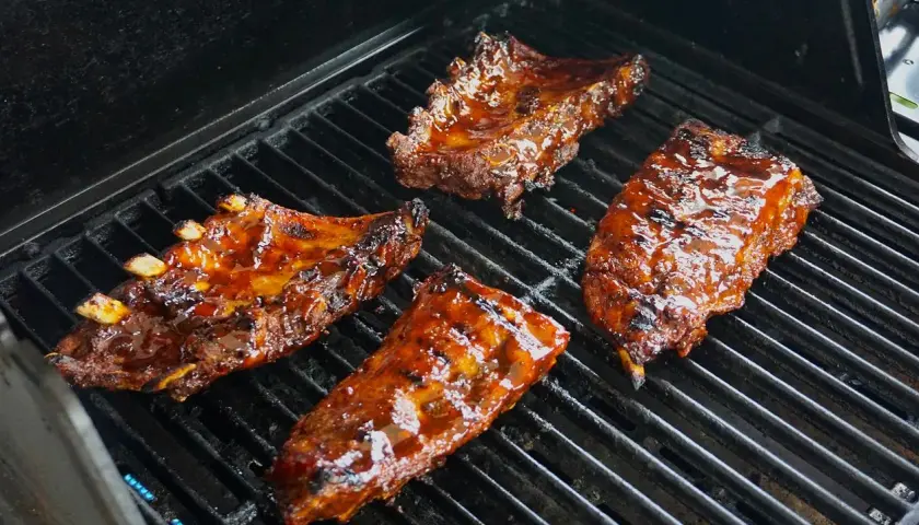 Soczyste żeberka w sosie barbecue grillują się na ruszcie. Idealne do marynowania w domowych sosach.