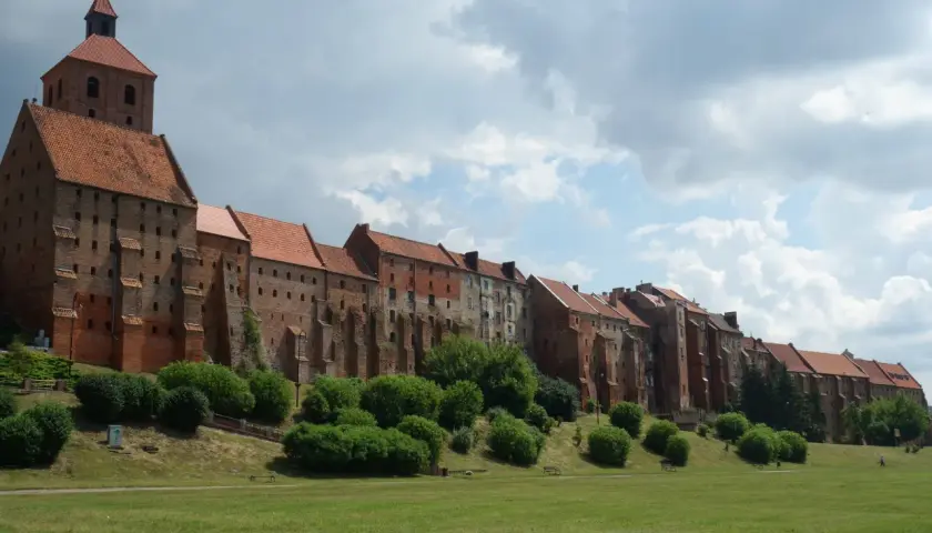 Grudziądz atrakcje na weekend: imponujące spichrze nad Wisłą, zielony teren rekreacyjny i malownicze niebo. Idealne miejsce na spacer.
