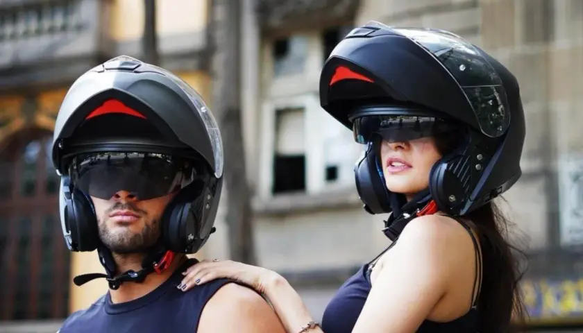 Pareja lista para rodar con sus cascos modulares, ofreciendo protección y estilo.