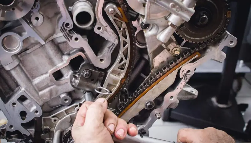 Mechanik pracuje przy rozrządzie silnika. Wymiana poduszki silnika może być konieczna, gdy pojawią się objawy takie jak wibracje.