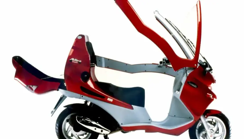 Moto con techo rojo y gris, con parabrisas y estructura de protección.