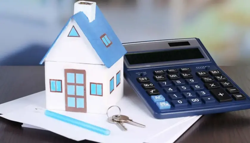 Modello di casa, calcolatrice e chiavi su fogli. Calcolo dell'IVA su infissi per la tua nuova casa.