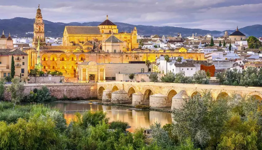 Puente Romano y Mezquita-Catedral de Córdoba, un ave que vuela sobre la historia, evocando un viaje desde Barcelona.