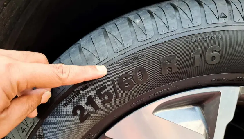 Palec wskazuje na oznaczenie rozmiaru kół 215/60 R16.