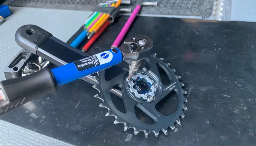 Using a Park Tool torque wrench to ensure proper SRAM chainring bolt torque for a bike repair.